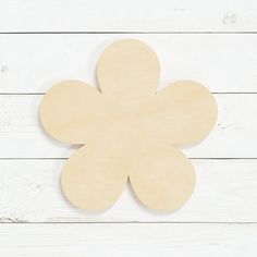 a wooden cutout of a flower on a white wood background