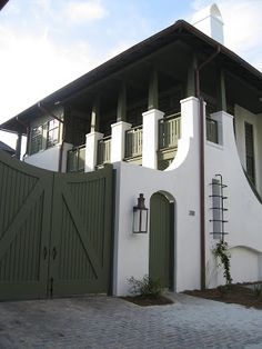 a large white house with green doors and windows