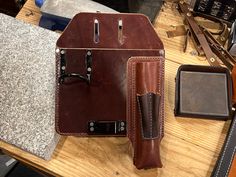 a brown leather case sitting on top of a wooden table