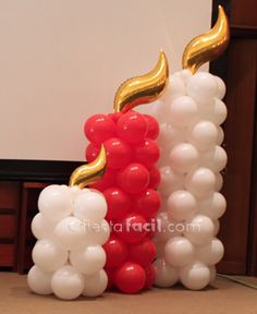 two tall white and red balloons in the shape of candles