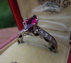 A gorgeous ring with a GIA certified 1.14 carat marquise cut no heat red ruby.  The feminine setting has 8 fine quality diamonds down the shoulders and also 18 tiny diamonds set into the sides of the setting with gold swags.  The finger size is a small 4.75 - 5.  I am not sure if this ring can be sized.  Show a photo to your jeweler before purchasing to confirm.  The ring weighs 5.3 grams and is marked 18K. The ring box shown is my display.  I will ship in a different antique box or you may request a new ring box. Ruby Diamond Ring, Ruby Diamond Rings, Gorgeous Ring, Antique Boxes, Tiny Diamond, No Heat, Ruby Diamond, Red Ruby, Marquise Cut