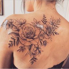 a woman's back with flowers and leaves on it