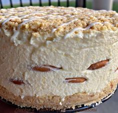 a cake with white frosting and pecans on top is sitting on a plate