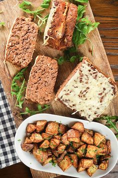 several different types of food on a cutting board next to a bowl of cheese and bread