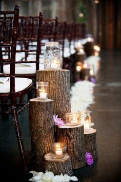 wedding decorations made out of tree stumps and mason jars are displayed on the floor