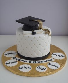 a graduation cake decorated with gold and white icing