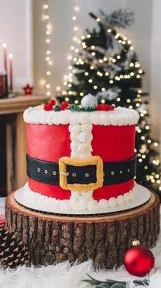 a decorated christmas cake sitting on top of a tree stump