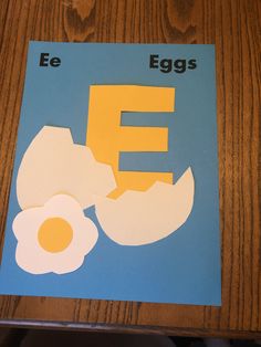 the letter e is for eggs cut out of paper and placed on a wooden table