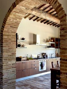 an archway in the kitchen leads into another room