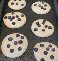 six blueberry cookies sitting on top of a cookie sheet in the oven, ready to be baked