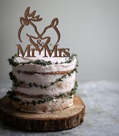 a cake that is sitting on top of a piece of wood with the word mr and mrs written on it