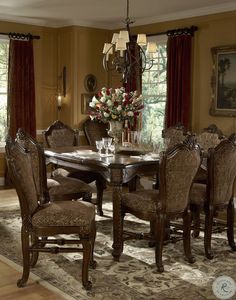 a formal dining room table and chairs with floral centerpiece