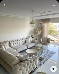 a living room filled with lots of furniture next to a glass floored area rug