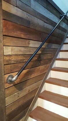 a wooden staircase with metal handrails and wood paneling