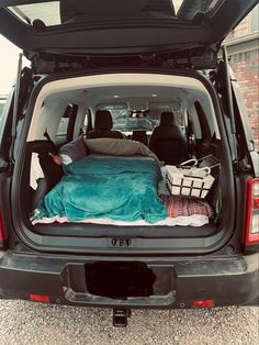 the back end of a van with an open trunk and bed in it's cargo area