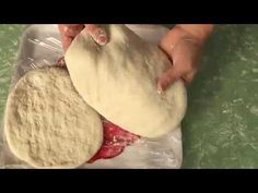 two uncooked pita breads are being held by someone's hand