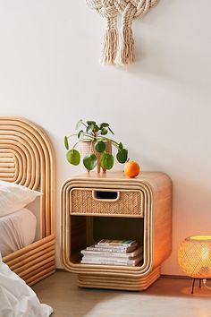 a bed room with a neatly made bed and a wicker nightstand next to it