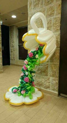 a balloon sculpture in the shape of a flowery tree with flowers on it's base