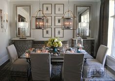 the dining room table is set with four chairs, and there are pictures on the wall behind it