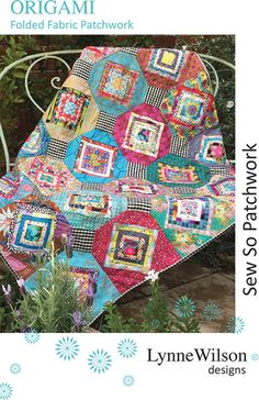 a quilted blanket sitting on top of a metal bench next to flowers and plants