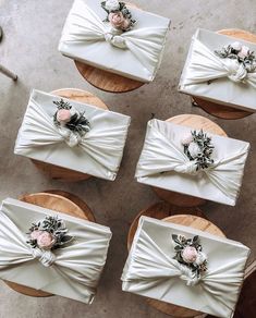 four white boxes with bows and flowers on them