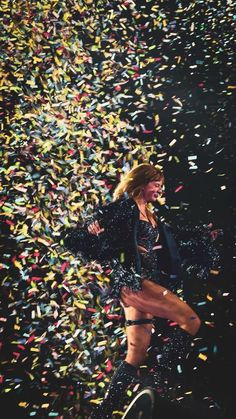 a woman standing on top of a stage surrounded by confetti