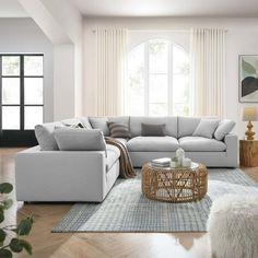 a living room filled with lots of furniture next to a large white couch and coffee table