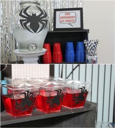 there are several cups with red liquid in them and one has a spiderman decal on it