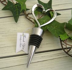 a wine bottle stopper with a heart shaped corkscrew hanging from it's side