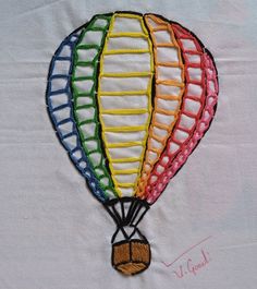 a colorful hot air balloon embroidered onto a white shirt