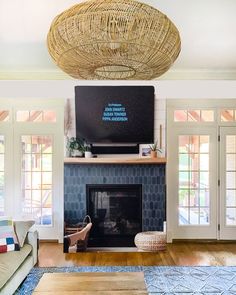 a living room with a fire place, couches and a television mounted on the wall