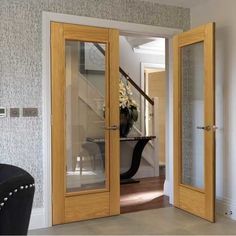 an open door leading to a foyer with glass panels on the front and back doors