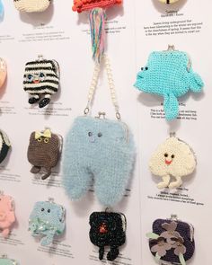 there are many knitted animals hanging on the display wall, all in different colors