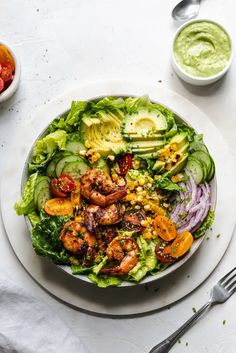 a white plate topped with salad and shrimp