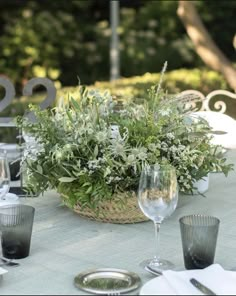 the table is set with silverware and greenery for an outdoor dinner party or celebration