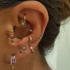 a close up of a person's ear with several different types of piercings