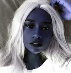 a woman with white hair and blue makeup