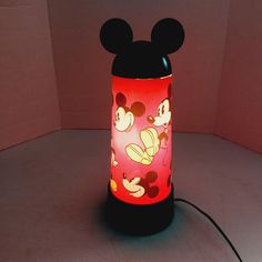 a mickey mouse lamp is lit up on the floor