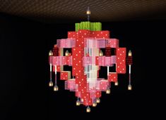 a red and white polka dot chandelier hanging from a ceiling in a dark room