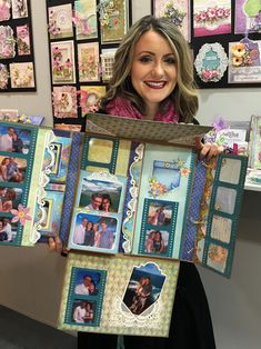 a woman holding up a scrapbook with pictures on the pages and photos in it