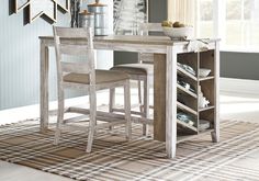 a dining room table with two stools next to it