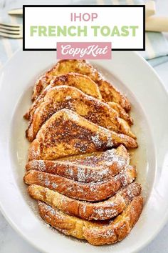 french toast with powdered sugar on top in a white bowl next to silverware