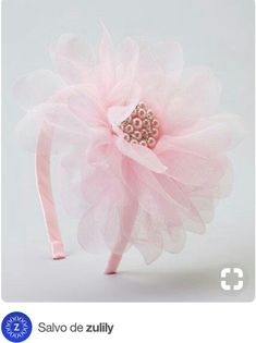 a pink headband with pearls and a large flower on the top is shown in front of a white background