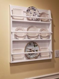 a white shelf with plates and dishes on it