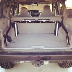 the back end of a vehicle with its cargo compartment open and two large bars attached to it