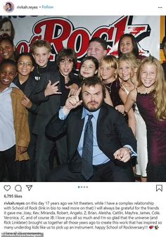 a group of people posing for a photo with a man in a suit and tie