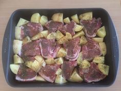 meat and potatoes in a pan on a table