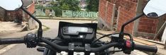 the handlebars and mirrors of a motorcycle parked in front of a brick building