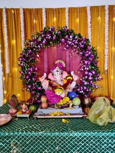 there is a statue of the god ganesh in front of flowers and garlands