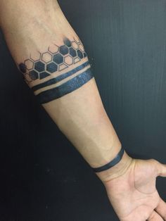 a man's arm with a tattoo on it that has honeycombs and stripes